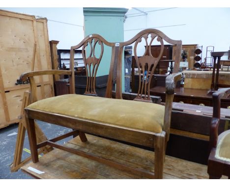 AN ANTIQUE MAHOGANY CHIPPENDALE STYLE TWIN BACKED CHAIR, THE HANDLES OF THE ARMS FOLIATE CARVED, THE DROP IN SEAT COVERED IN 