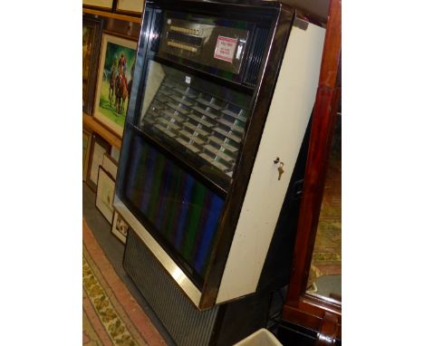 A SEEBURG JUKE BOX TO PLAY A SELECTION OF FORTY EIGHT DISCS WITH THEIR TITLES BEHIND GLASS ABOVE A LIGHT DISPLAY.&nbsp;