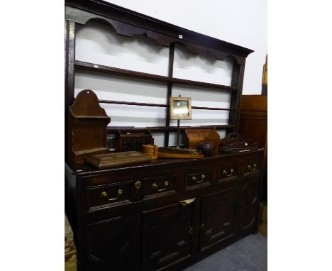 AN OAK DRESSER WITH OPEN SHELF BACK, THE BASE WITH THREE DRAWERS ABOVE TWO CRUCIFORM PANELLED DOORS. W 171 x D 46 x H 184cms.