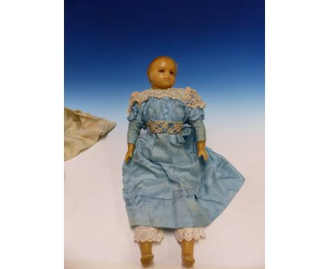 A 19th C. SLEEPY EYED WAX DOLL IN A BLUE SILK DRESS BUT WITH SPARE CLOTHES IN SIDE A BOX DECORATED AS A TRAVEL TRUNK, THE DOL