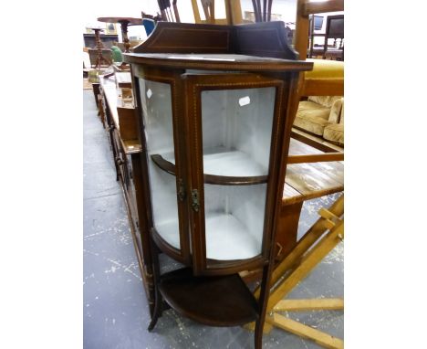 A EDWARDIAN BARBERS POLE LINE INLAID MAHOGANY CORNER CUPBOARD, THE BOW FRONTED DOORS ENCLOSING TWO SHELVES ABOVE ANOTHER SHEL