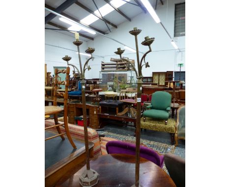 A PAIR OF NEOGOTHIC BRASS THREE LIGHT CANDELABRA ON CYLINDRICAL OAK COLUMNS AND OCTAGONAL FEET.   H 109cms.