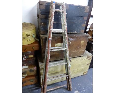 A RUSTIC PAINTED WOOD LADDER WITH SIX RUNGS ON ONE SIDE AND FIVE ON THE OTHER
