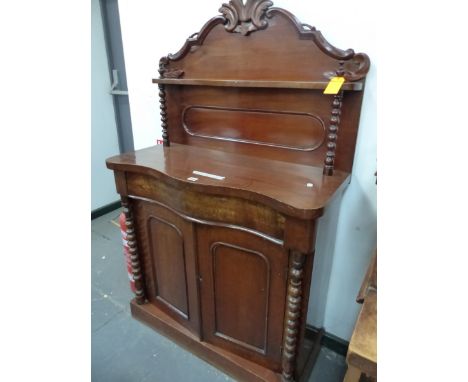 A VICTORIAN SERPENTINE FRONTED MAHOGANY CHIFFONIER SIDE CABINET, THE BACK WITH A FOLIATE CARVED TOP ABOVE A SHELF WITH BOBBIN