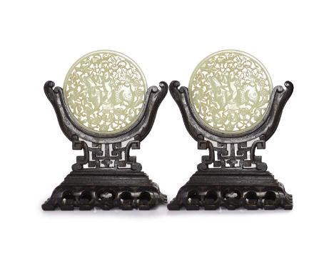   A pair of Chinese pale celadon jade circular plaques, late 19th century,each reticulated and carved with a boy riding a qil