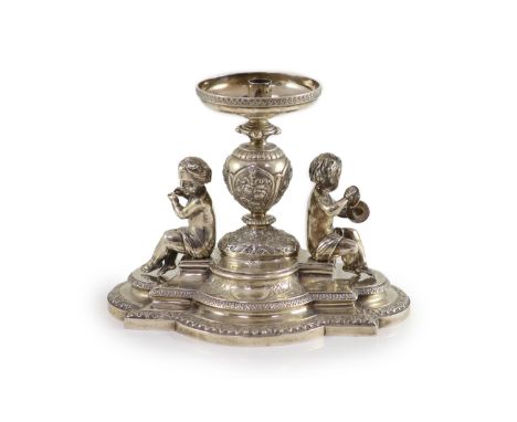   A Victorian silver centrepiece (lacking trumpet),with engraved and embossed foliate decoration and surmounted with two chil