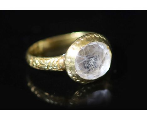   An early George I engraved gold, rock crystal and two colour enamel set memento mori ring,the facetted stone above a skull 