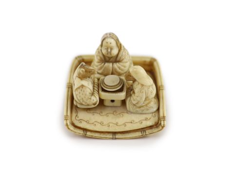   A Japanese ivory netsuke of figures seated around a table, Meiji period,the underside carved with basket weave, unsigned,4.