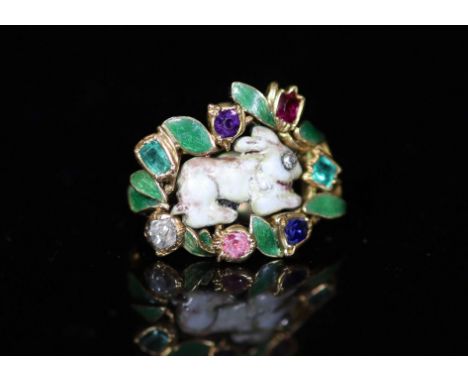   A late 19th/early 20th century French gold, enamel and multi gem set ring,with central hare motif and bordered with gem sto