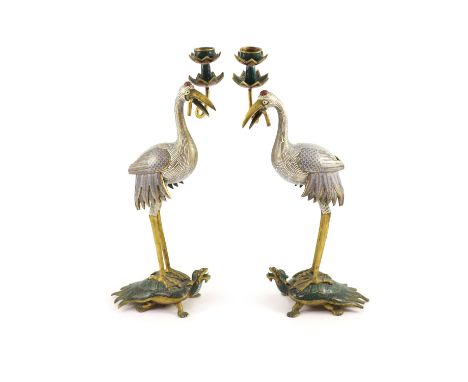   A pair of Chinese cloisonné enamel and gilt bronze ’crane’ candlesticks, early 20th century,each modelled holding a floral 