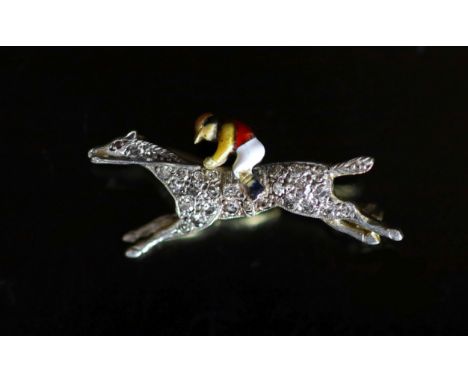   An early 20th century gold, diamond chip and enamel set 'horse and jockey' brooch,32mm, gross 4.5 grams.