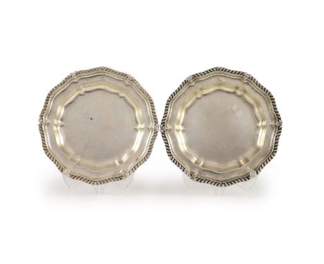   A pair of late George IV silver shaped circular dinner plates by Paul Storr,decorated with gadrooned and leaf borders and e
