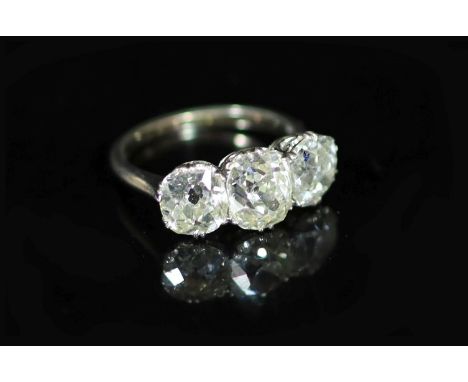   A platinum? and three stone diamond ring,set with three old cushion cut stones, with a total diamond weight approximately e