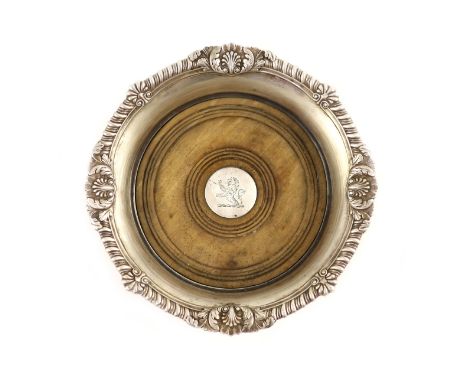   A George III silver wine coaster by Paul Storr,with gadrooned and foliate border and turned wooden base, London, 1812, the 