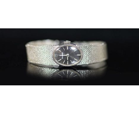   A lady's 9ct white gold Tudor manual wind oval wrist watch,with baton numerals, on integral 9ct white gold bracelet, case d