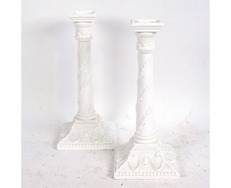 A pair of Royal Worcester white glaze porcelain candlesticks with relief moulded decoration, pattern no. 1050, height 27cm 