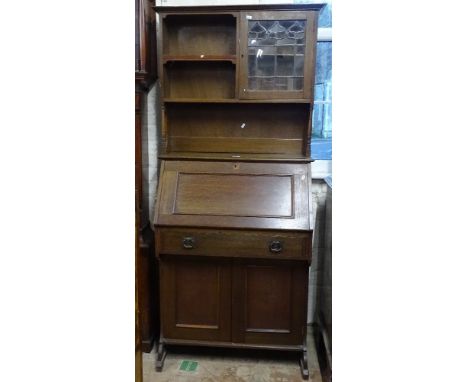 An Art Nouveau oak student's 2-section bureau, with a lead-light glazed and open shelf top, with fall-front and cupboards und