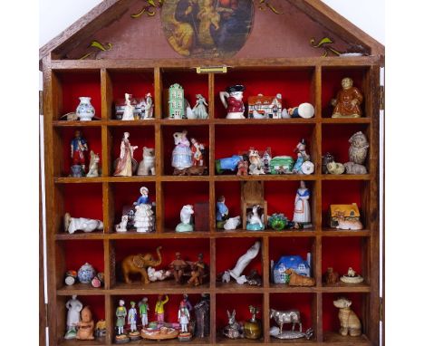 A wall-hanging glazed display cabinet, containing various collectables, including elephant netsuke, miniature silver pheasant