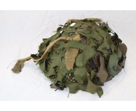 A British Army Helmet With Orignal Liner, Webbing And Camouflage. Dated To The Inside For 1979.