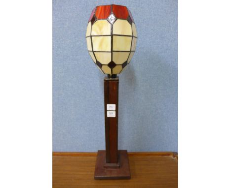 A wooden table lamp with Tiffany style glass shade