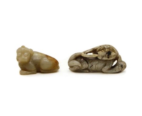 A Chinese jade carving,in the Ming style, of a recumbent Buddhist lion holding a brocaded ball, 7.5cm long, and another jade 