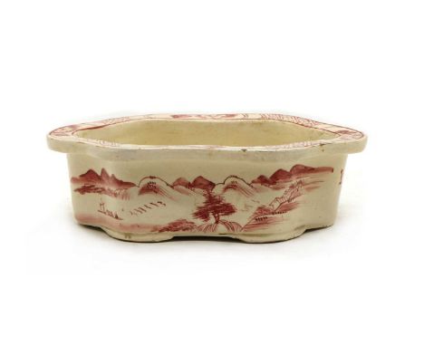 A Chinese planter, Republic period (1912-1949), of lobed hexagonal form on four bracket feet, painted in ruby-red enamel with
