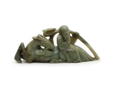 A Chinese jade carving, 20th century, of Shoulao carrying a staff with double gourds over his shoulder, seated on the back of