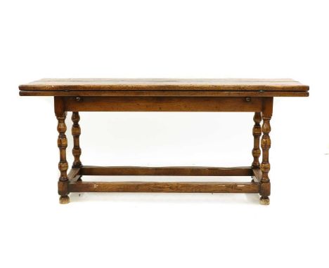 A 17th century-style folding oak dining table, 20th century, the plank top with metal hinges, supported by lopers, raised on 