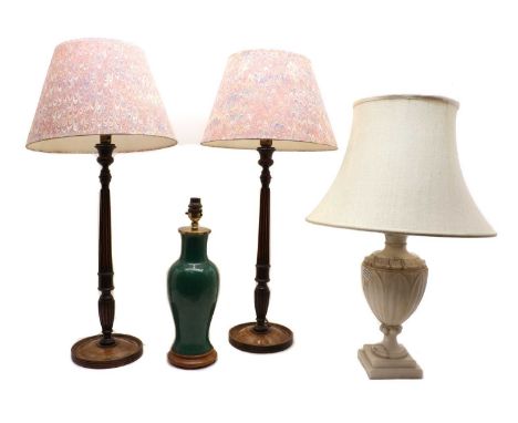 A pair of mahogany table lamps,raised on turned and reeded column, loaded bases, with marbled paper shades, 74cm overall toge