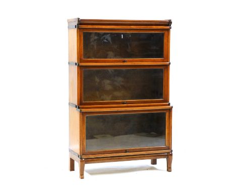 A walnut Globe Wernick modular bookcase,early 20th century, of three sections, each with a bakelite handle, raised on short c