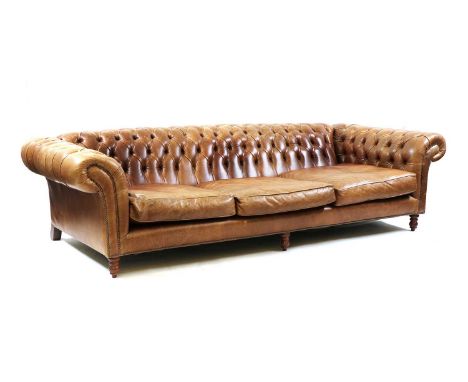 A large chesterfield sofa,of recent manufacture, the button back and cushion seats, upholstered in saddle brown hive, on turn