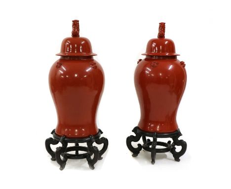 A pair of large Chinese-style red vases and covers,of recent manufacture, each of baluster shape with a Fo dog finial and fou