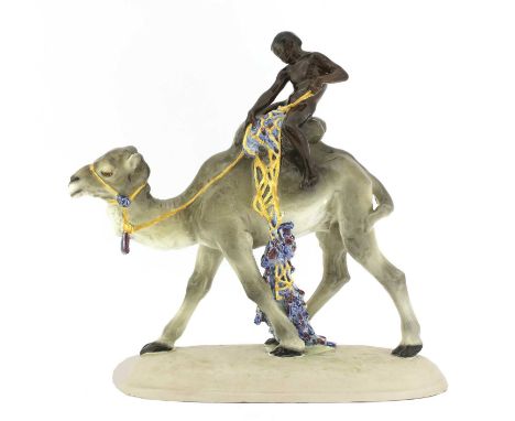 A Goldscheider pottery group of a boy on a camel,by Ferdinand Doblinger (Austrian,1872-1935), modelled as a naked boy seated 