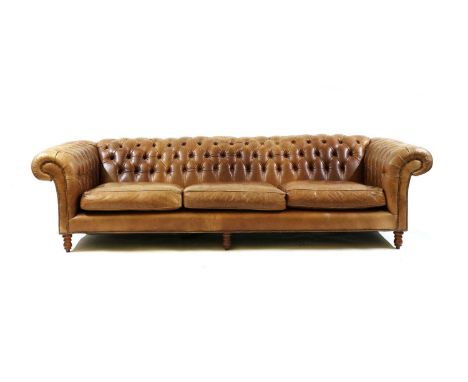 A large Chesterfield sofa,of recent manufacture, the button back and cushion seats upholstered in saddle brown hive, on turne