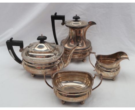 A George V silver four piece tea set comprising a teapot, hot water jug, cream jug and twin handled sugar basin, Birmingham,.