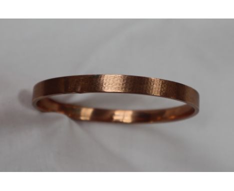 A 9ct yellow gold bangle, with engine turned decoration, approximately 12 grams, 8cm diameter on outside edge, 74mm internal 