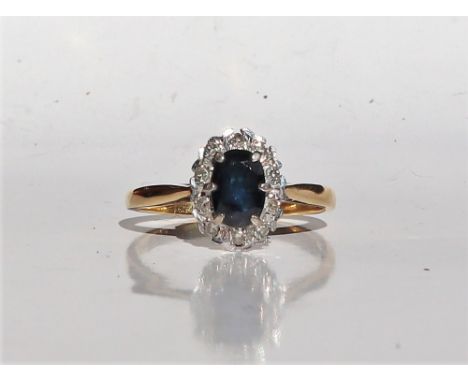 A sapphire and diamond ring, the central oval faceted sapphire measuring approximately 7mm x 6mm surrounded by round brillian