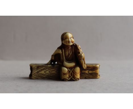 A 19th century Japanese ivory netsuke in the form of an elderly lady seated on a log, 27mm high