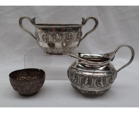 An Indian white metal twin handled sugar basin, with serpent handles, the body with buddhistic roundels and leaves, marked C.