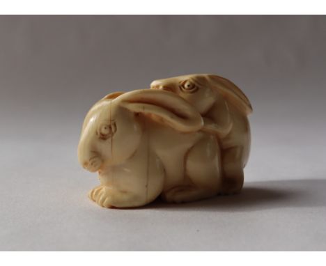 A 19th century Japanese ivory netsuke depicting mating hares, signed, 30mm 