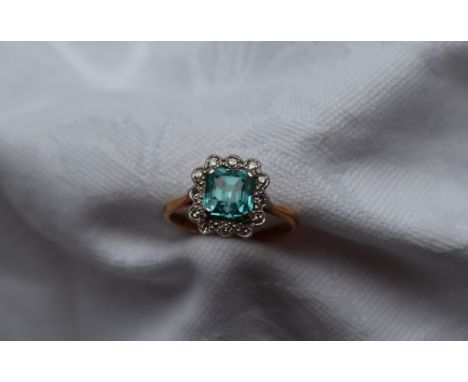 A topaz and diamond cluster ring, the central square cut topaz surrounded by round old cut diamonds to a white metal setting 