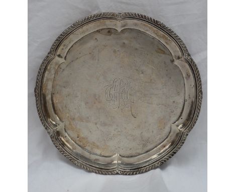 An Edward VII silver salver, with a lobed gadrooned edge, the centre engraved, on three scrolling feet, London, 1907, R &amp;