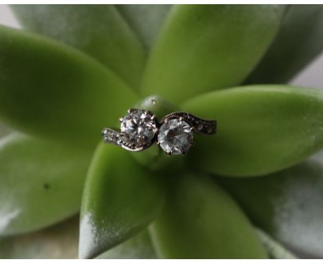 A two stone dress ring, crossover set with diamond simulants to a white metal setting marked 9ct, size K, approximately 2.8 g