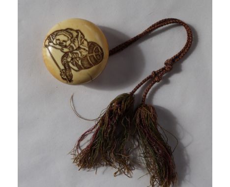 A 19th century Japanese ivory Manju Netsuke, carved with a boy playing with a rat, with a basket behind him, 50mm diameter