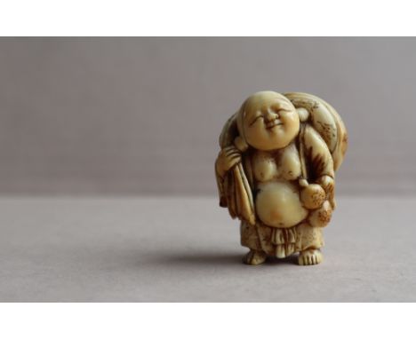 A 19th century Japanese ivory netsuke depicting Hotei standing holding a gourd flask with a sack over his right shouder, his 