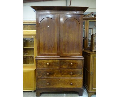 A Victorian mahogany linen press,&nbsp;the cornice above two panelled doors enclosing four slides, the lower part fitted with