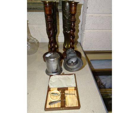 A pair of brass trenchwork shell cases with embossed floral and fluted decoration, 34.5cm high, a pair of oak twist candlesti