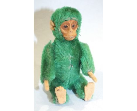 A rare Schuco green mohair monkey compact, c1920's, the detachable head revealing a lipstick, the body opening to reveal a co