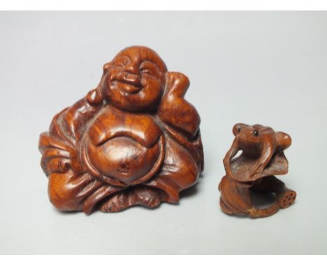 A CARVED WOODEN SIGNED NETSUKE IN THE FORM OF A FROG SEATED ON A LILY PAD, H 2.5 cm, together with a carved wooden Buddha H 4