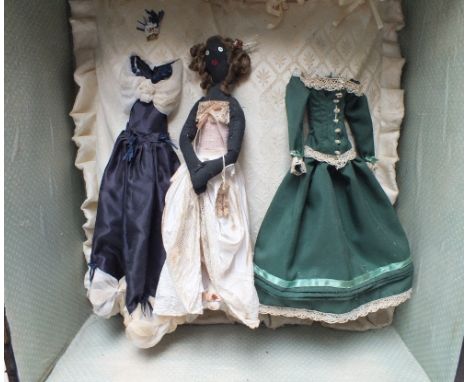 A CASED ANTIQUE COLONIAL DOLL 'MISS PEARL - TRAVELLING COMPANION', mounted in a display case with a dress to either side, cas